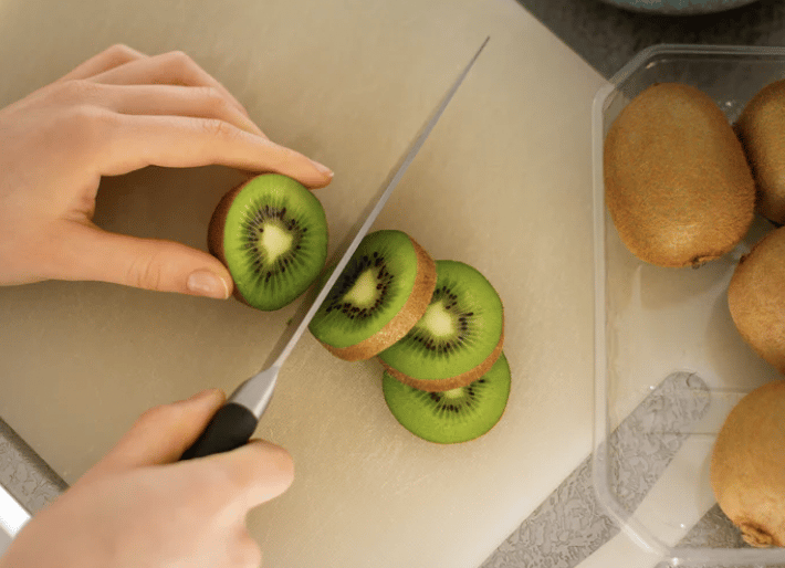 Quelqu'un qui coupe un kiwi