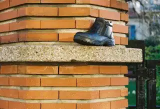 black leather work boots on gray concrete stairs